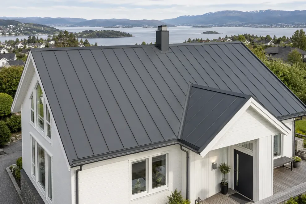 Illustrasjon av en bolig med mørkt metalltak og stående falser.